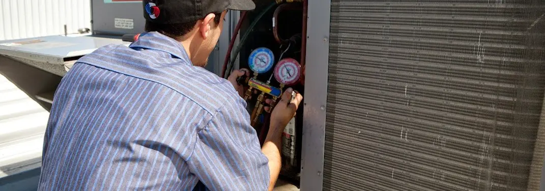 HVAC technician servicing a condenser unit in Southaven